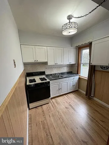 a kitchen with granite countertop a stove a sink and a refrigerator