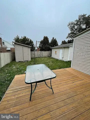 a view of a terrace with wooden floor and a yard