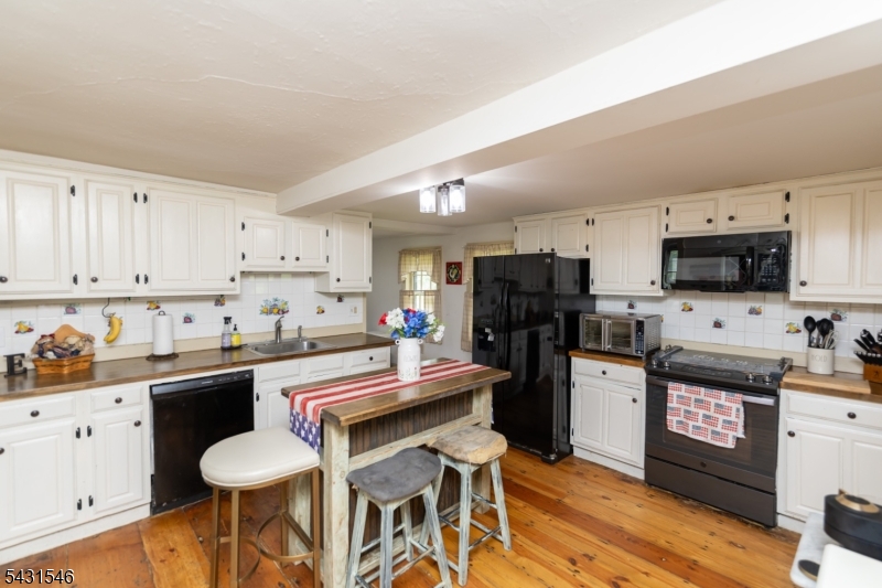 490 Mine Road Asbury, NJ 08802 - Photo 12 of 39 a kitchen with stainless steel appliances a stove top oven a sink dishwasher and a refrigerator with wooden floor