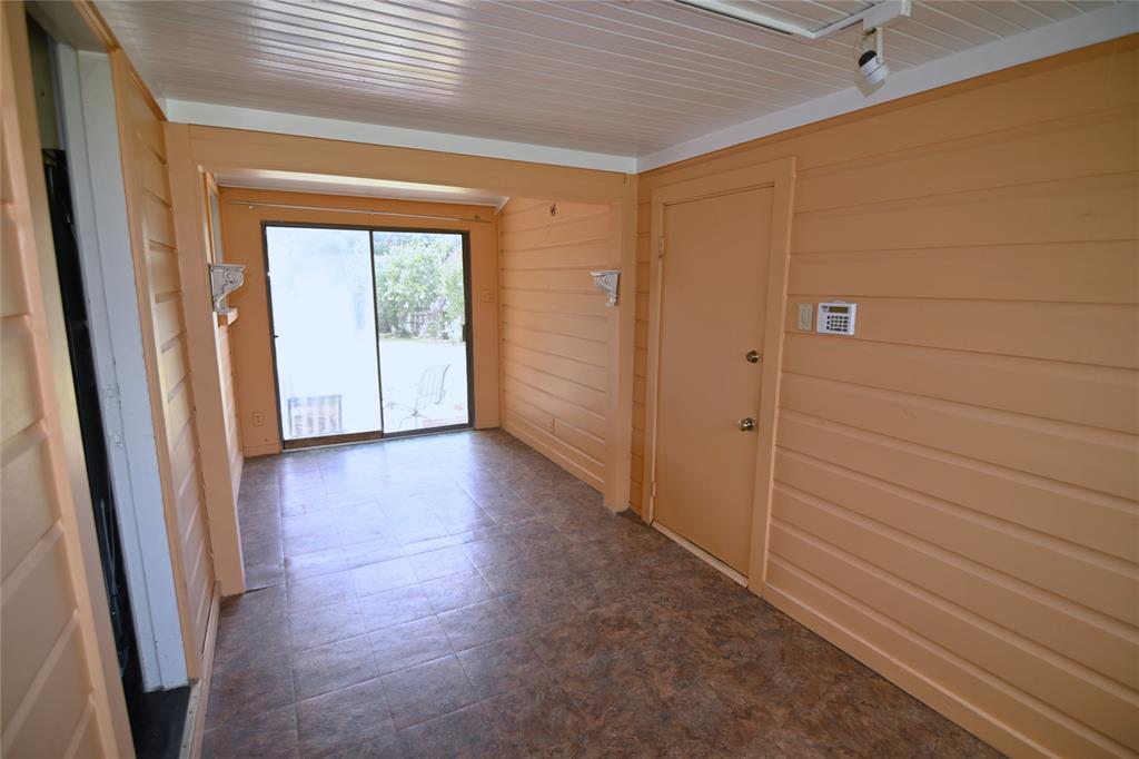 1916 Tierney Road Fort Worth, TX 76112 - Photo 7 of 12 Corridor with wood walls, wooden ceiling, and dark floors