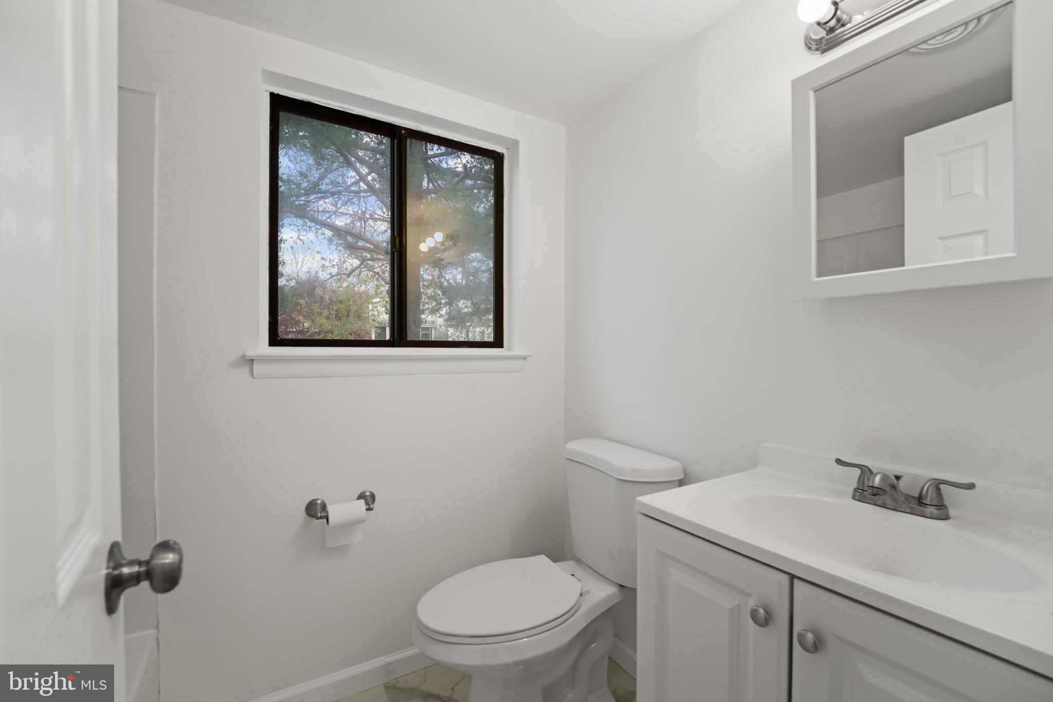 856 Putnam Boulevard, Unit 67A Wallingford, PA 19086 - Photo 11 of 26 a bathroom with a toilet sink vanity and mirror