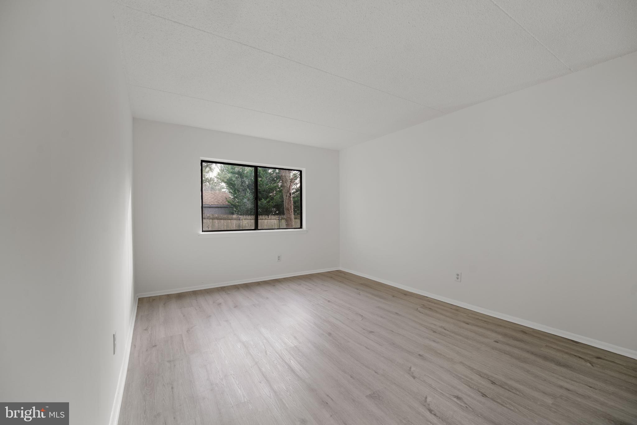 856 Putnam Boulevard, Unit 67A Wallingford, PA 19086 - Photo 13 of 26 an empty room with wooden floor and windows