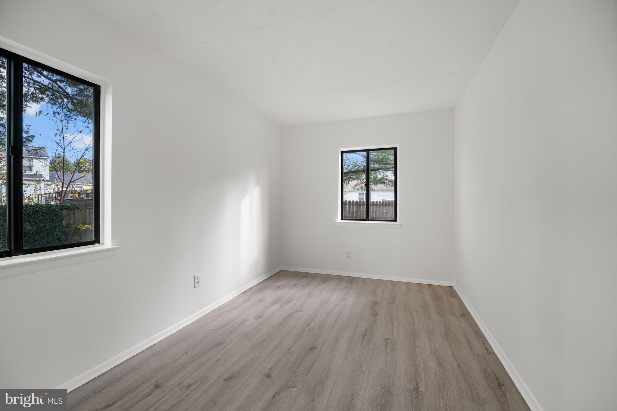 856 Putnam Boulevard, Unit 67A Wallingford, PA 19086 - Photo 15 of 26 a view of an empty room with wooden floor and a window
