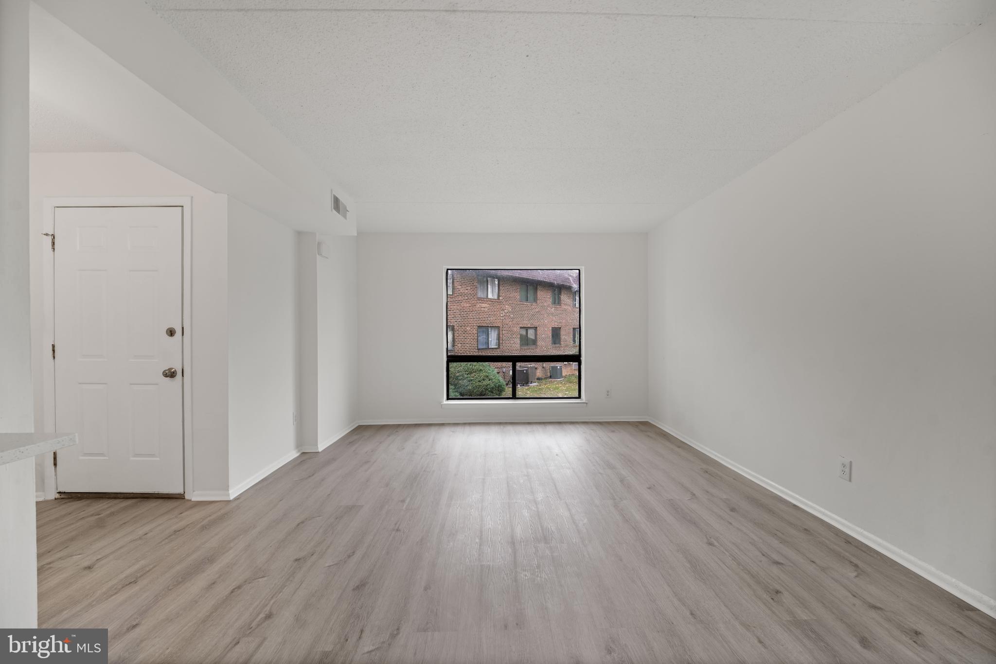 856 Putnam Boulevard, Unit 67A Wallingford, PA 19086 - Photo 4 of 26 an empty room with wooden floor and windows