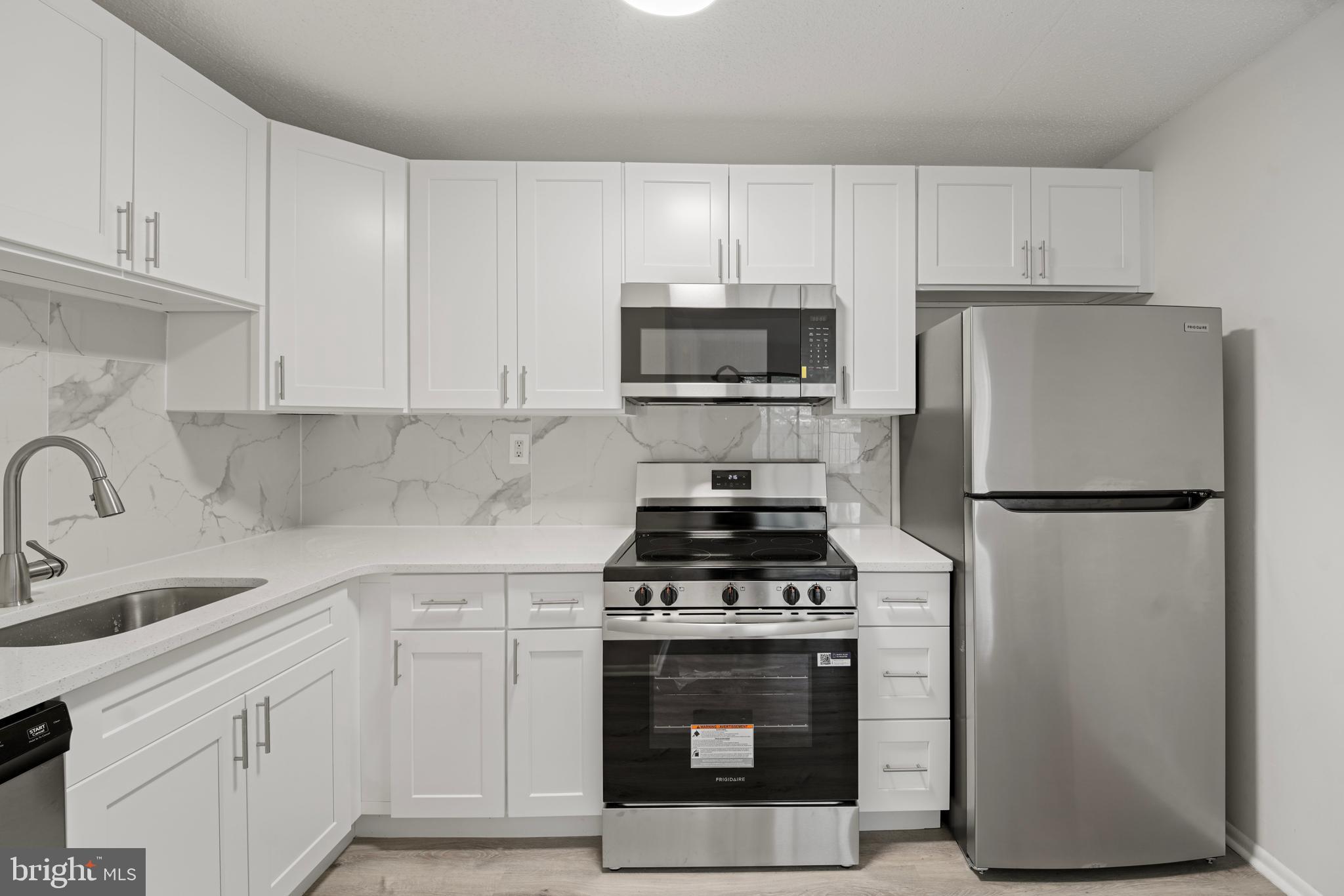 856 Putnam Boulevard, Unit 67A Wallingford, PA 19086 - Photo 9 of 26 a kitchen with cabinets stainless steel appliances and a sink