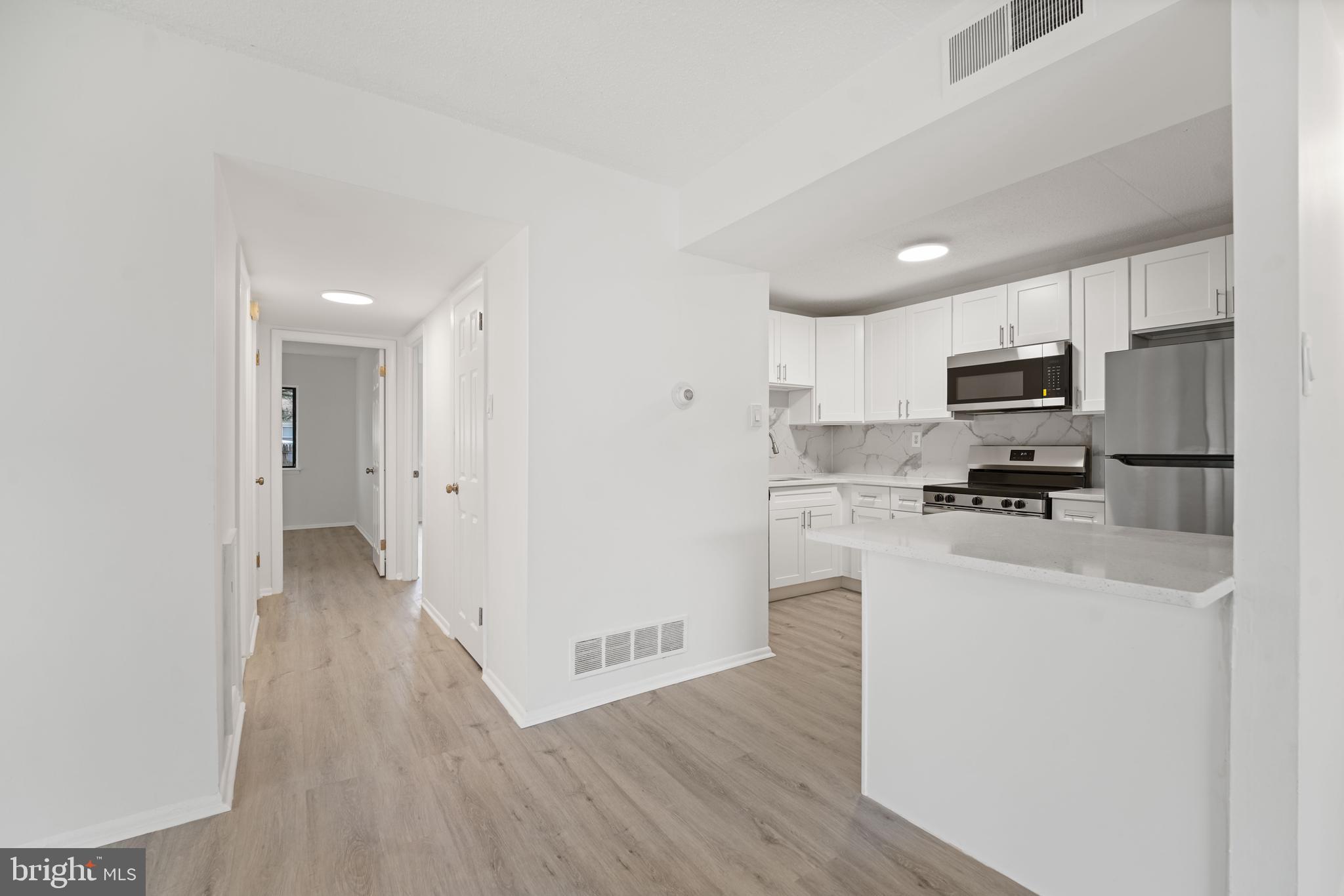 856 Putnam Boulevard, Unit 67A Wallingford, PA 19086 - Photo 10 of 26 a view of a kitchen with wooden floor and electronic appliances