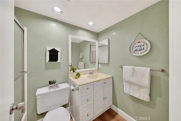 a bathroom with a toilet sink vanity and mirror