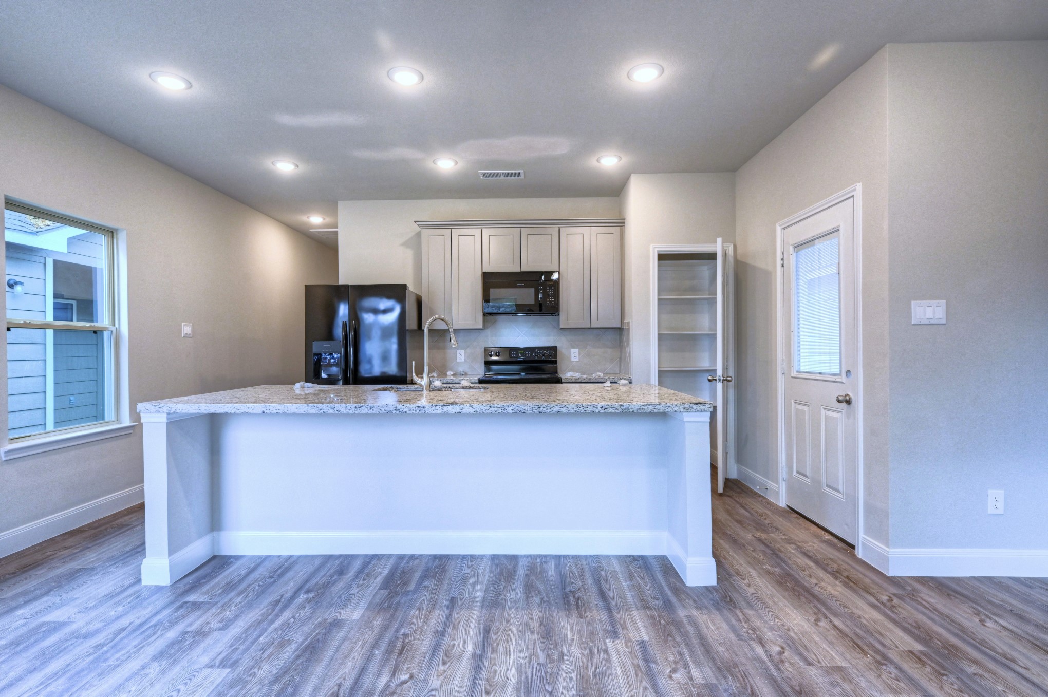 9173 Inwood Willis, TX 77318 - Photo 6 of 31 an open kitchen with wooden floor and a refrigerator