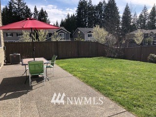 3032 Eagle Loop Northeast Lacey, WA 98516 - Photo 22 of 23 a view of a chairs and table under an umbrella in backyard
