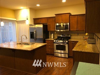 3032 Eagle Loop Northeast Lacey, WA 98516 - Photo 4 of 23 a kitchen with a sink a counter top space and cabinets