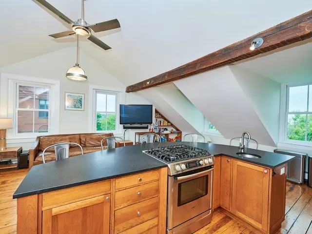 a view of a rooftop deck with couch and chairs