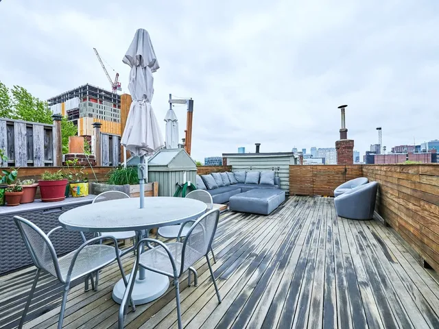 a view of roof deck with couches and wooden floor
