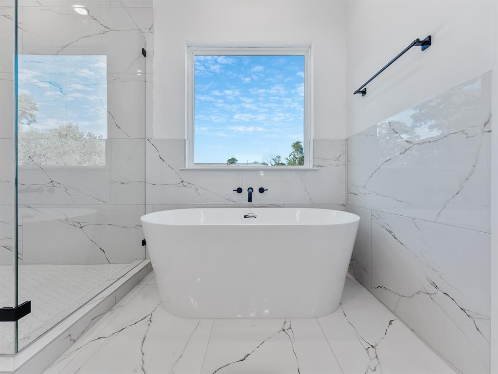 a white bath tub sitting next to a shower