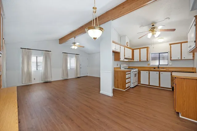 a kitchen with stainless steel appliances granite countertop a sink a stove and cabinets