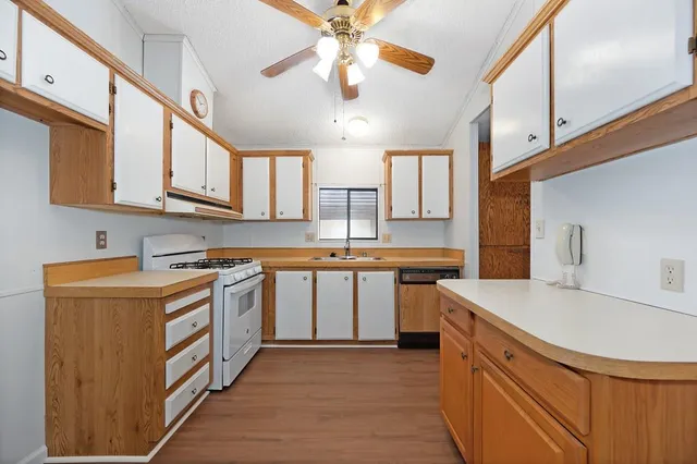 a kitchen with stainless steel appliances granite countertop a sink a stove and cabinets