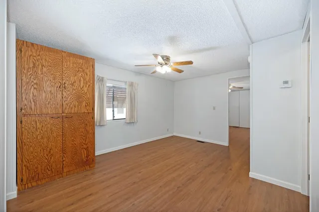 a view of a livingroom with wooden floor and a ceiling fan