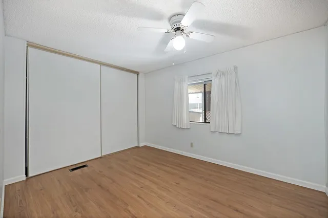 a view of a room with a ceiling fan and a window