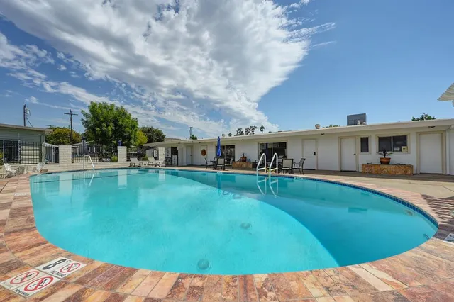 a swimming pool with outdoor seating and patio