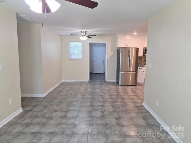 an empty room with closet and a chandelier fan