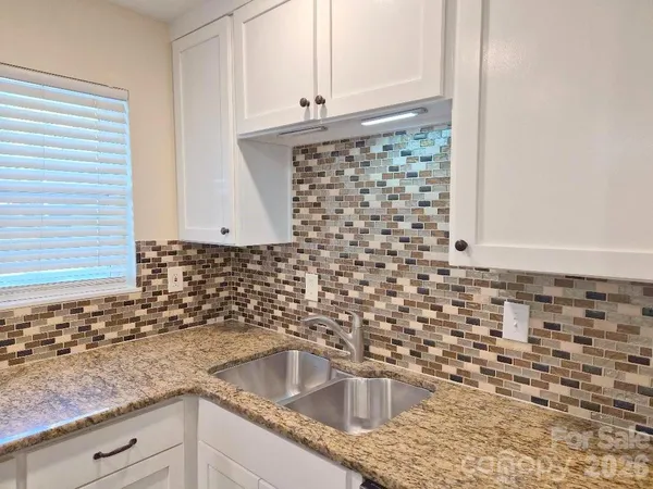 a kitchen with granite countertop a sink and a stove