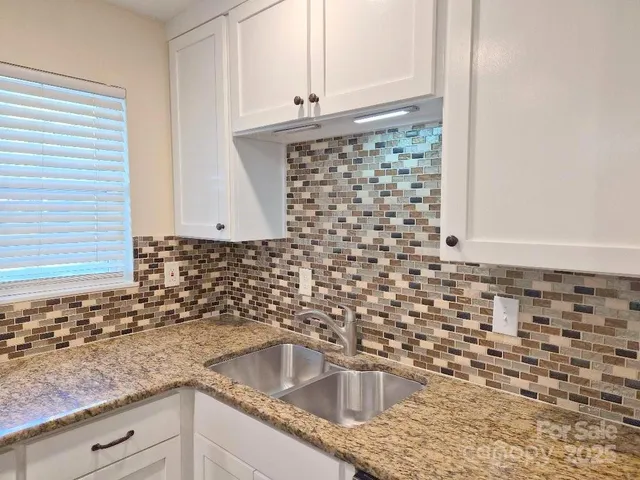 a kitchen with granite countertop a sink and a stove