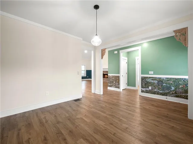 a view of a room with wooden floor staircase and a kitchen