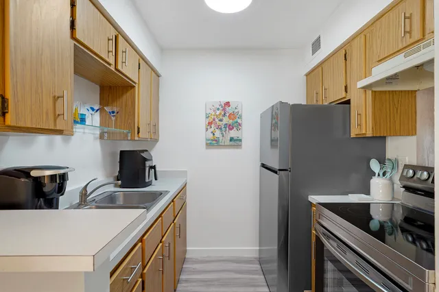 a kitchen with stainless steel appliances granite countertop a sink stove and refrigerator