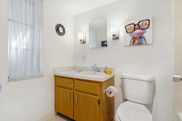 a bathroom with a toilet a sink and mirror