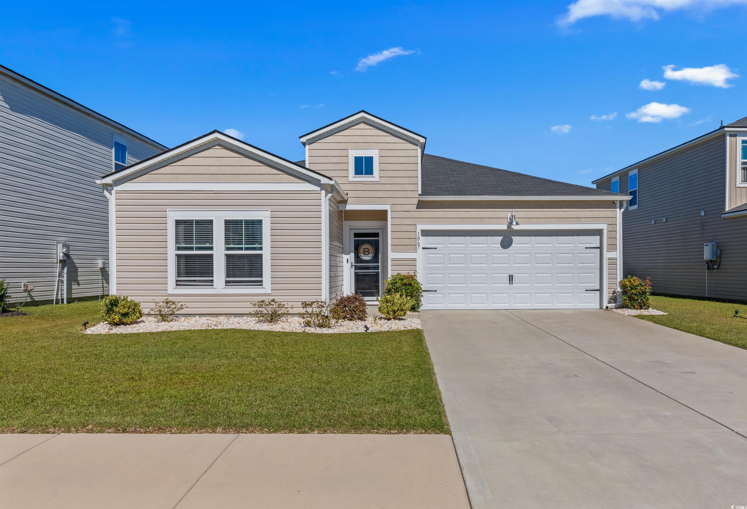 1067 Saltgrass Way Myrtle Beach, SC 29588 - Photo 1 of 40 View of front of home featuring concrete driveway, a front yard, and an attached garage