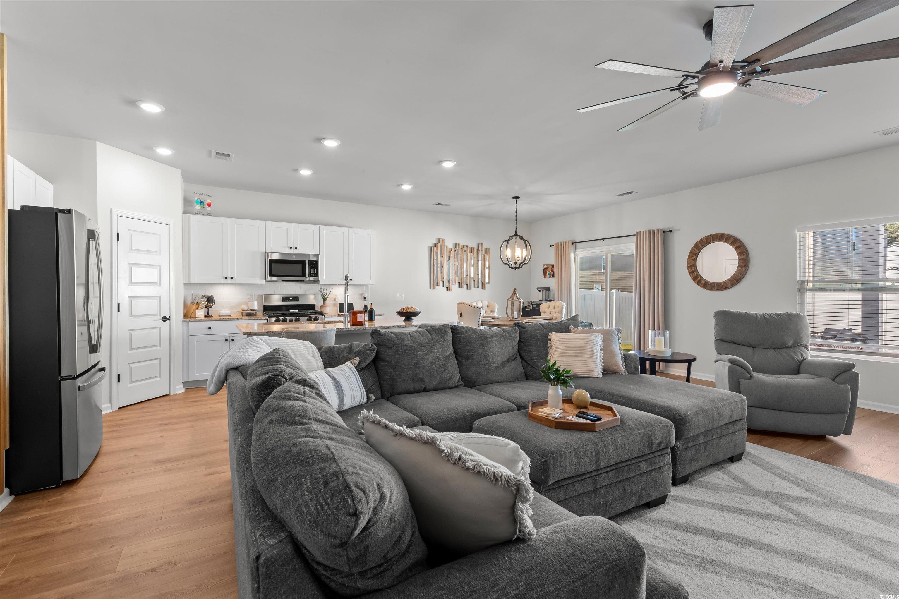 1067 Saltgrass Way Myrtle Beach, SC 29588 - Photo 16 of 40 Living area featuring recessed lighting, plenty of natural light, light wood finished floors, ceiling fan, and a chandelier