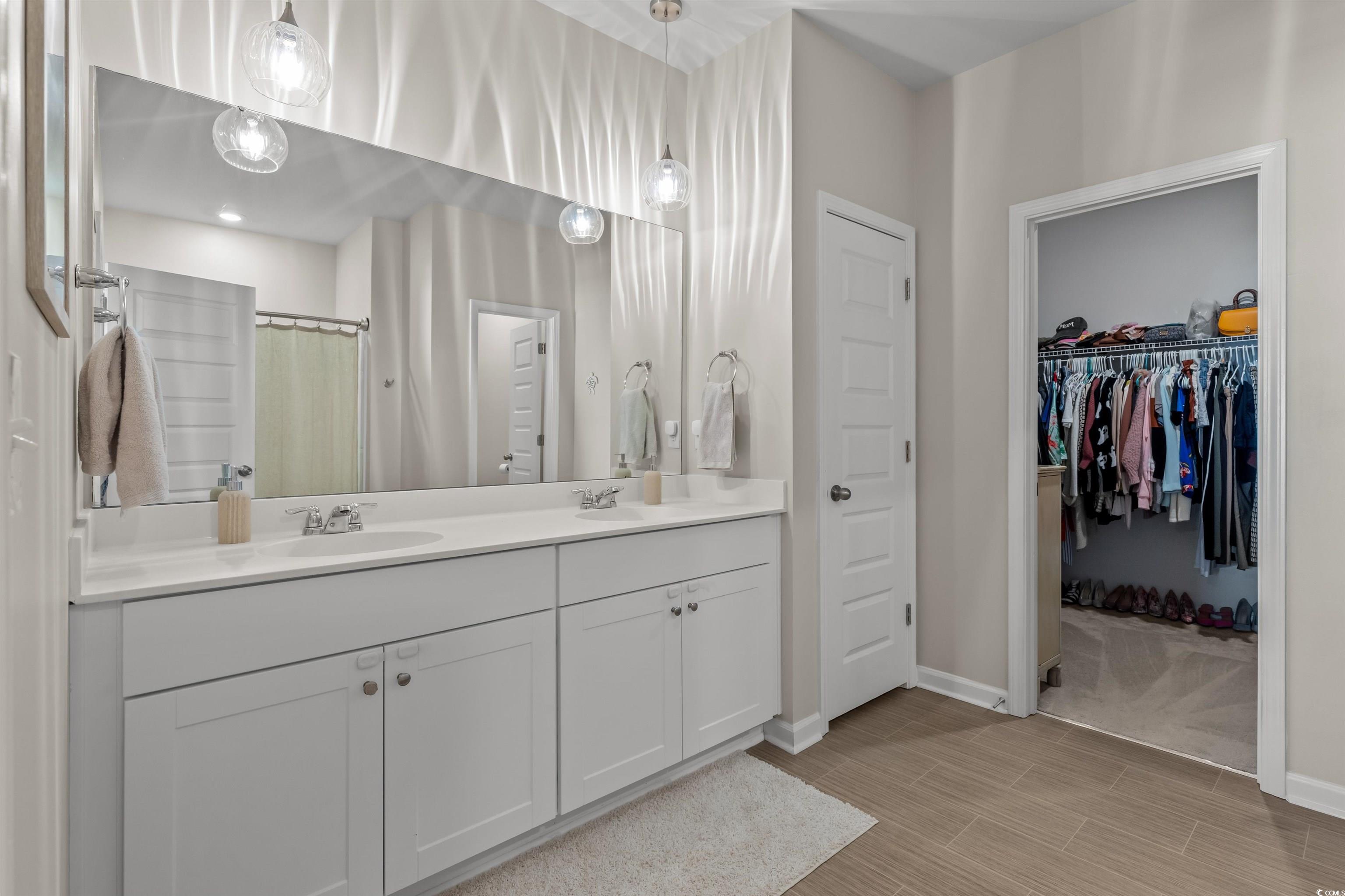 1067 Saltgrass Way Myrtle Beach, SC 29588 - Photo 31 of 40 Bathroom with a shower with curtain, double vanity, a walk in closet, and wood tiled floors