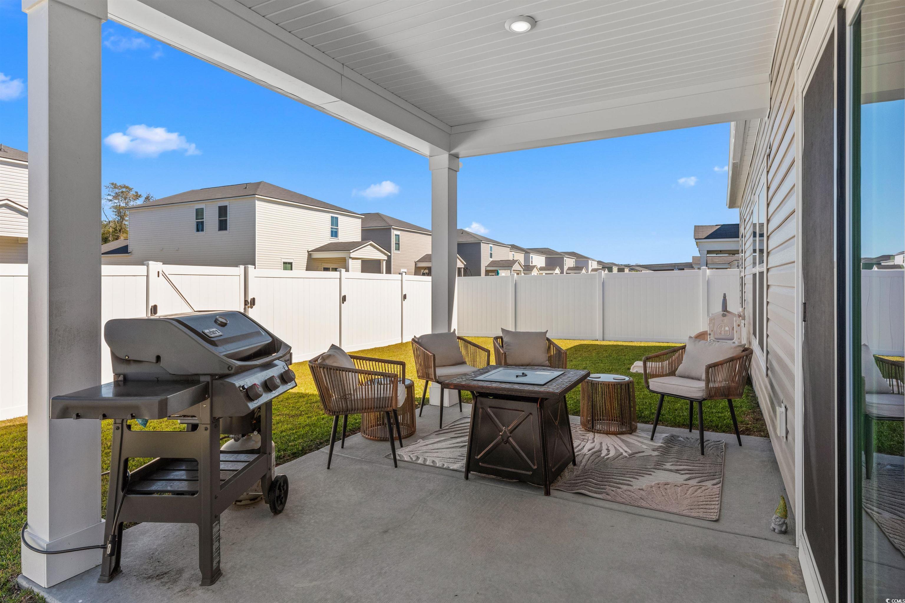 1067 Saltgrass Way Myrtle Beach, SC 29588 - Photo 36 of 40 Fenced backyard with an outdoor fire pit, a grill, and a patio