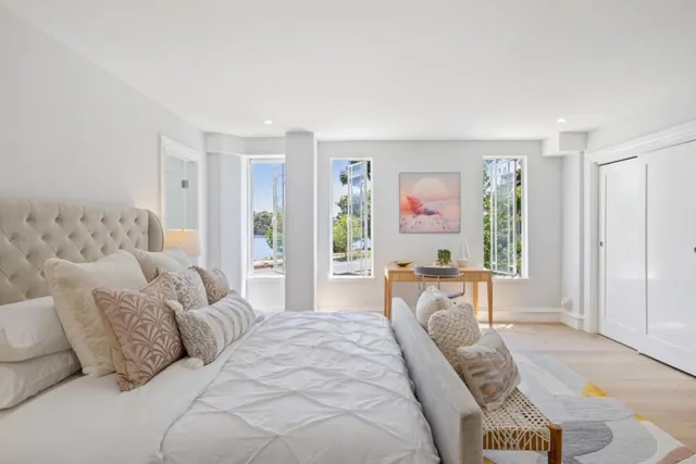 a spacious bedroom with a bed a couch and large window