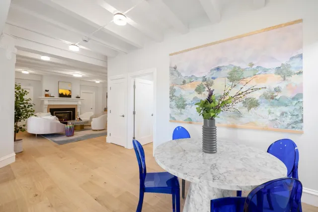 a kitchen with kitchen island a stove a sink a refrigerator a dining table and chairs