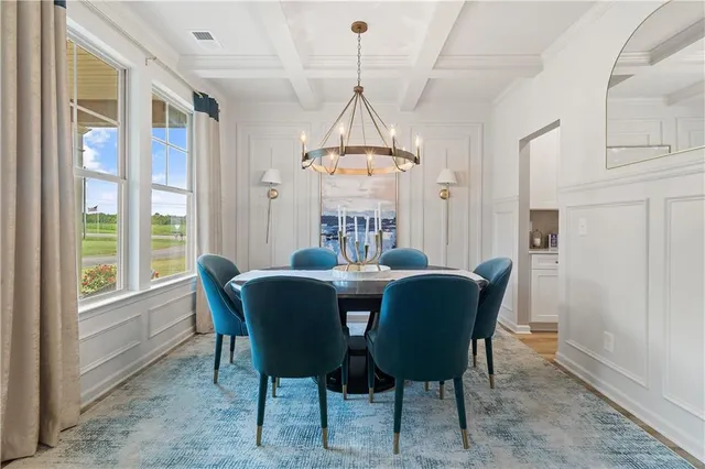 a dining room with furniture a chandelier and wooden floor