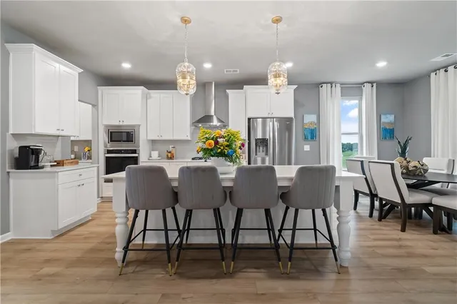 a view of a dining room and livingroom with furniture wooden floor a chandelier