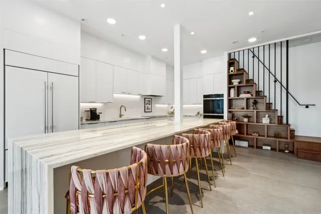 a kitchen with stainless steel appliances kitchen island granite countertop a table chairs and a refrigerator