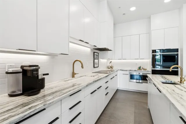 a large kitchen with granite countertop a sink and a stove