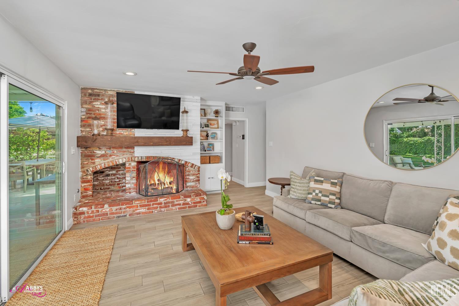 Undisclosed Address Bakersfield, CA 93309 - Photo 15 of 30 a living room with furniture a fireplace a flat screen tv and a large window
