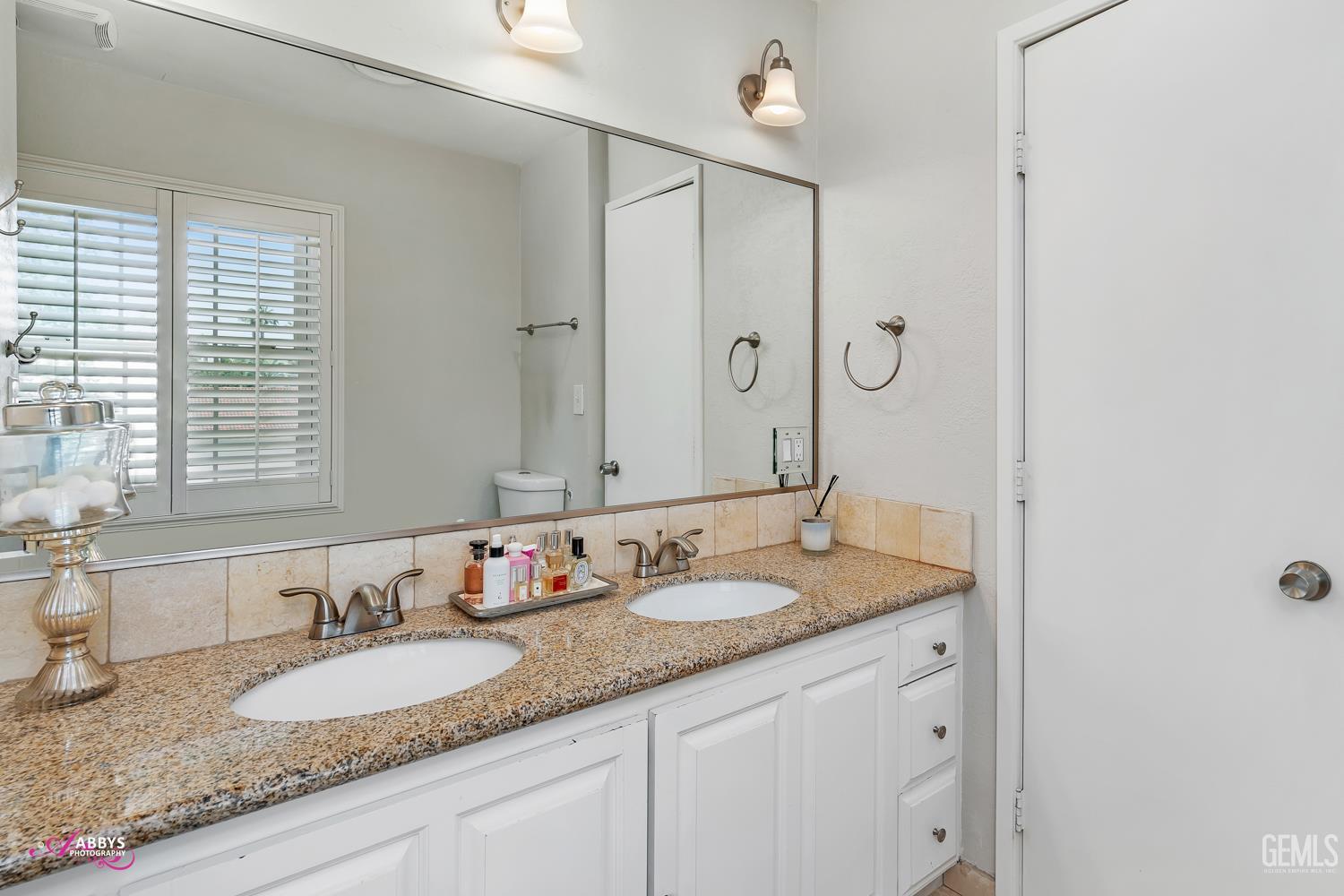 Undisclosed Address Bakersfield, CA 93309 - Photo 23 of 30 a bathroom with a granite countertop double vanity sink and a mirror