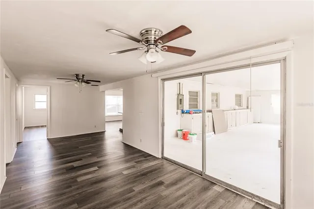 a view of a livingroom with wooden floor and a ceiling fan