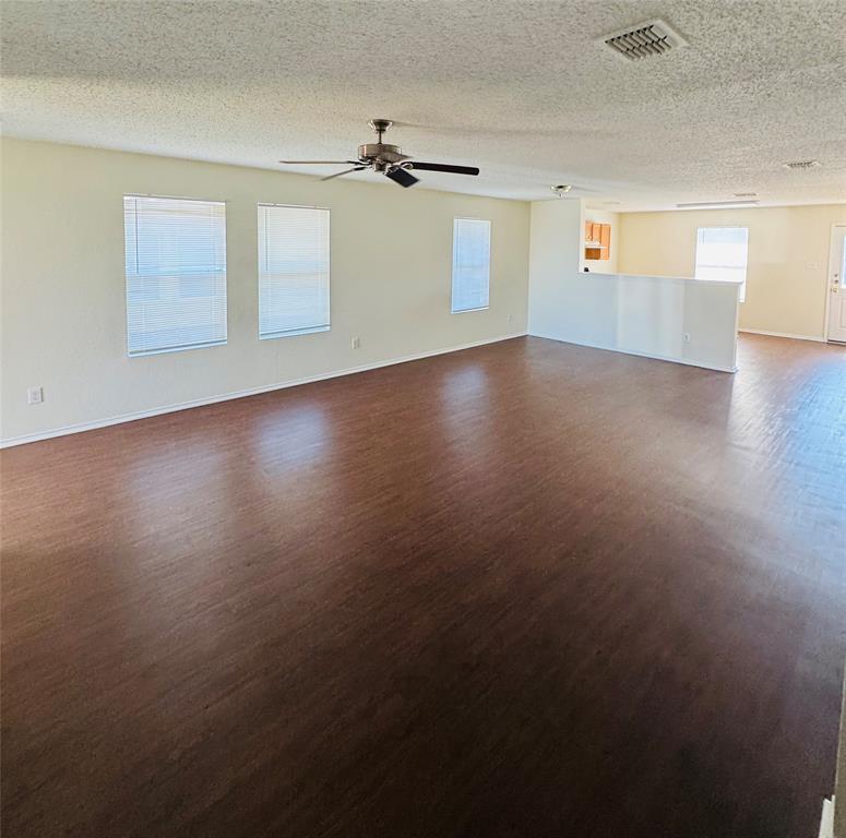 255 Meadowcrest Drive Terrell, TX 75160 - Photo 2 of 4 an empty room with wooden floor cabinet and windows