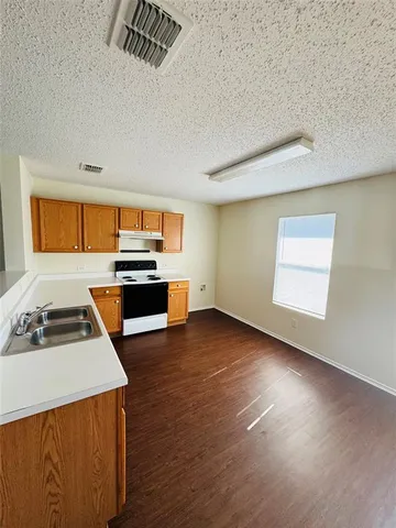 a kitchen with granite countertop a stove and a sink