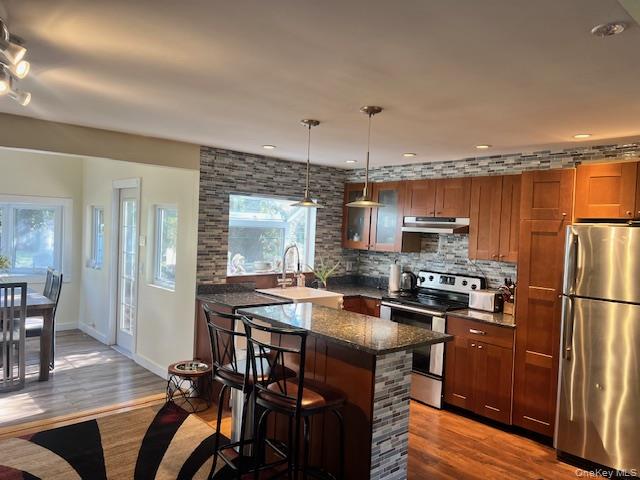 16 Lilac Road Westhampton Beach, NY 11978 - Photo 12 of 25 a kitchen with stainless steel appliances a stove a refrigerator and wooden floor