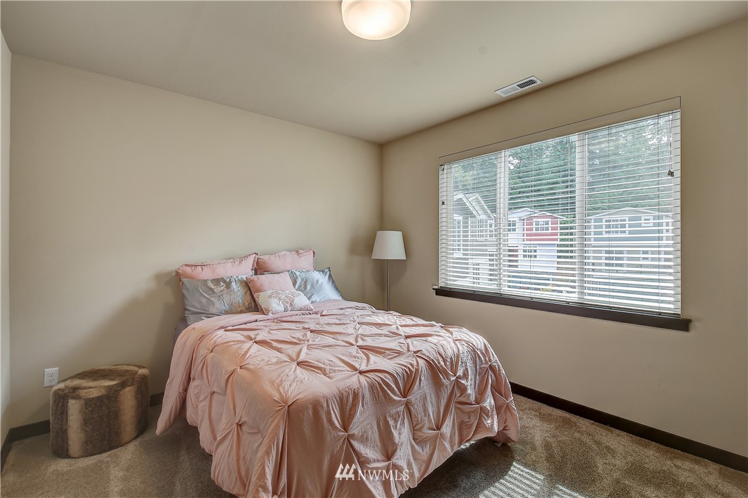 22810 23rd Avenue Southeast, Unit 2 Bothell, WA 98021 - Photo 11 of 16 a bed sitting in a bedroom next to a window