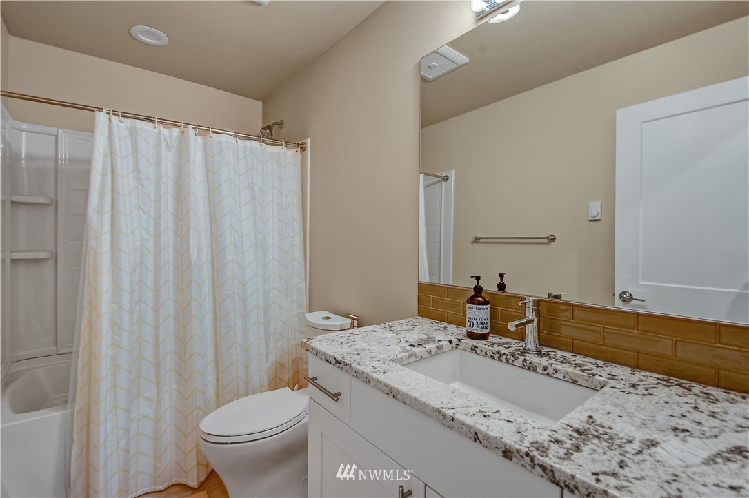 22810 23rd Avenue Southeast, Unit 2 Bothell, WA 98021 - Photo 15 of 16 a bathroom with a granite countertop sink and a mirror