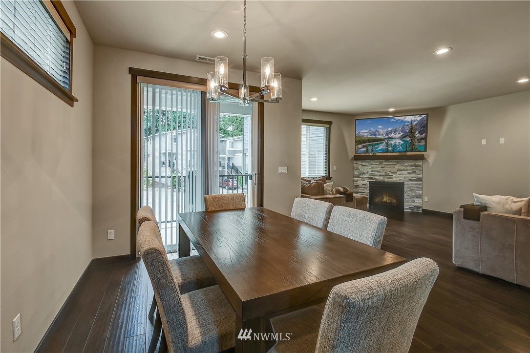 22810 23rd Avenue Southeast, Unit 2 Bothell, WA 98021 - Photo 6 of 16 a view of a livingroom and dining room with furniture wooden floor a chandelier