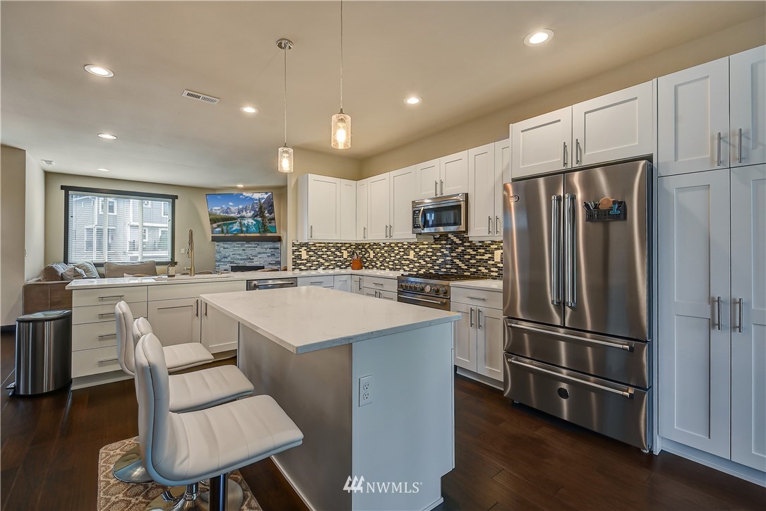 22810 23rd Avenue Southeast, Unit 2 Bothell, WA 98021 - Photo 7 of 16 a kitchen with white cabinets and stainless steel appliances