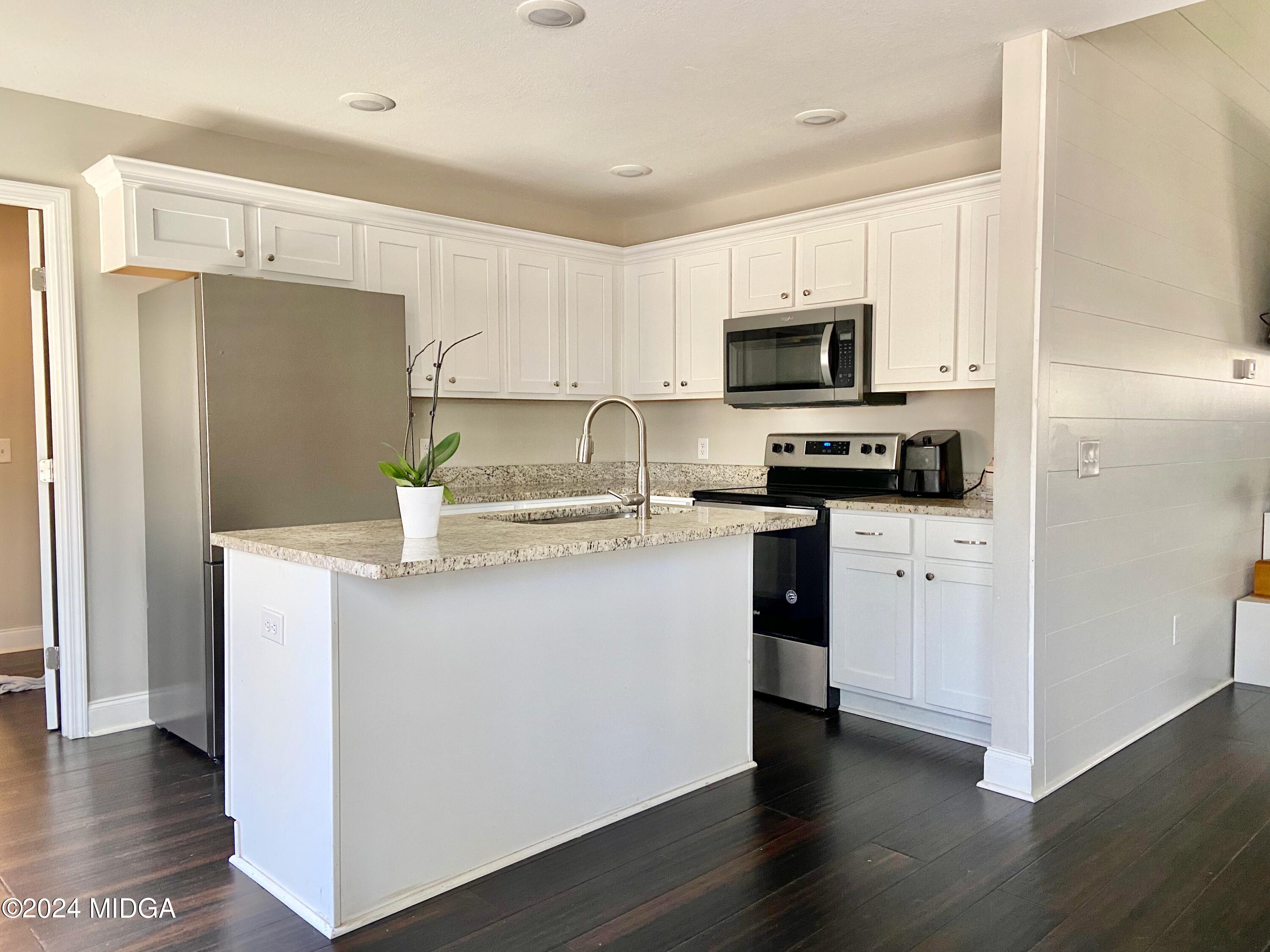461 Schofill Road Fort Valley, GA 31030 - Photo 13 of 24 a kitchen with cabinets stainless steel appliances and wooden floor