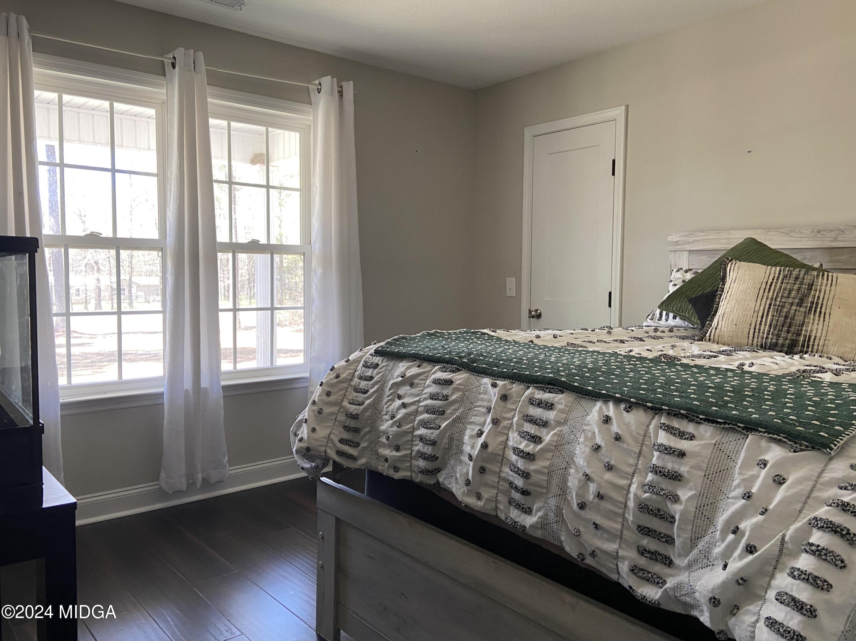 461 Schofill Road Fort Valley, GA 31030 - Photo 16 of 24 a bedroom with a bed and wooden floor